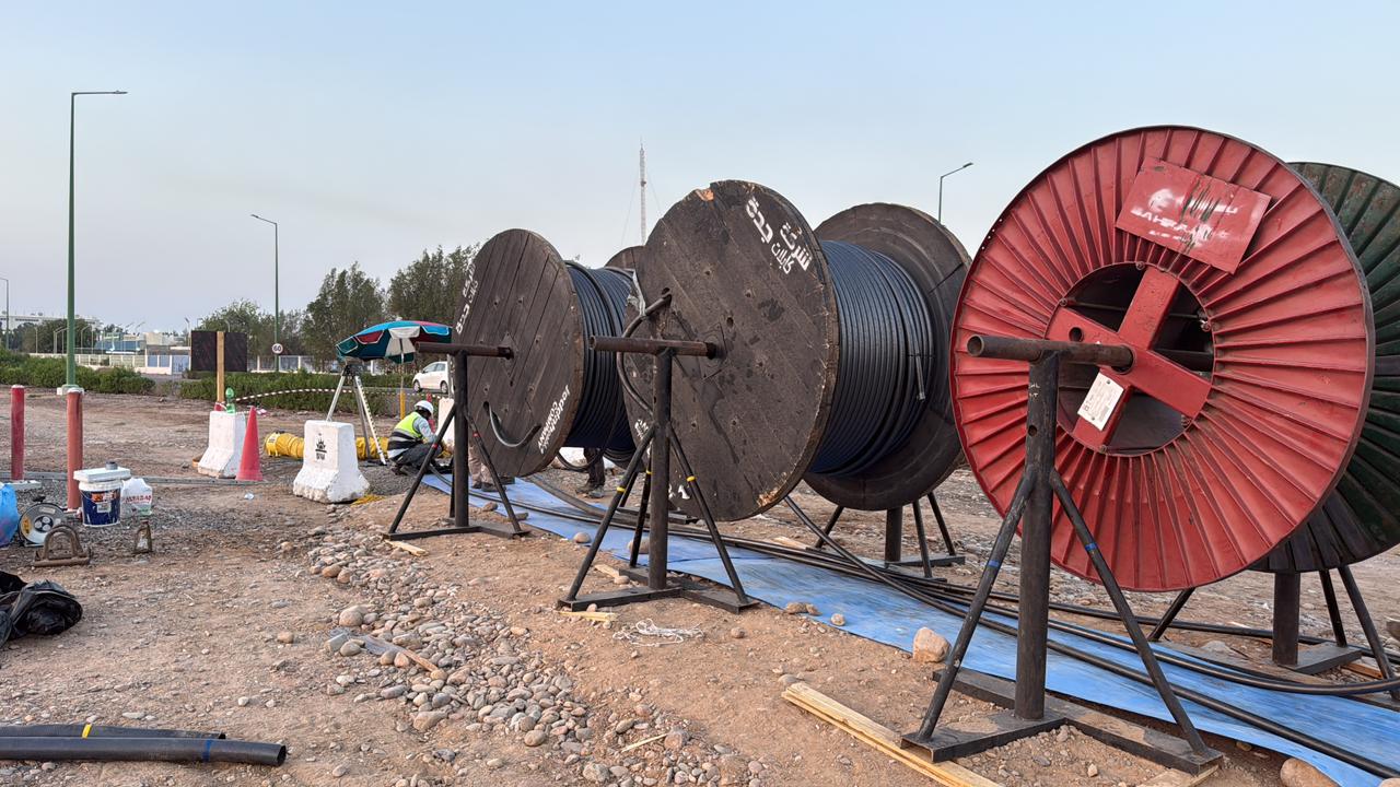 Medium voltage cable drums stacked in a fenced site compound